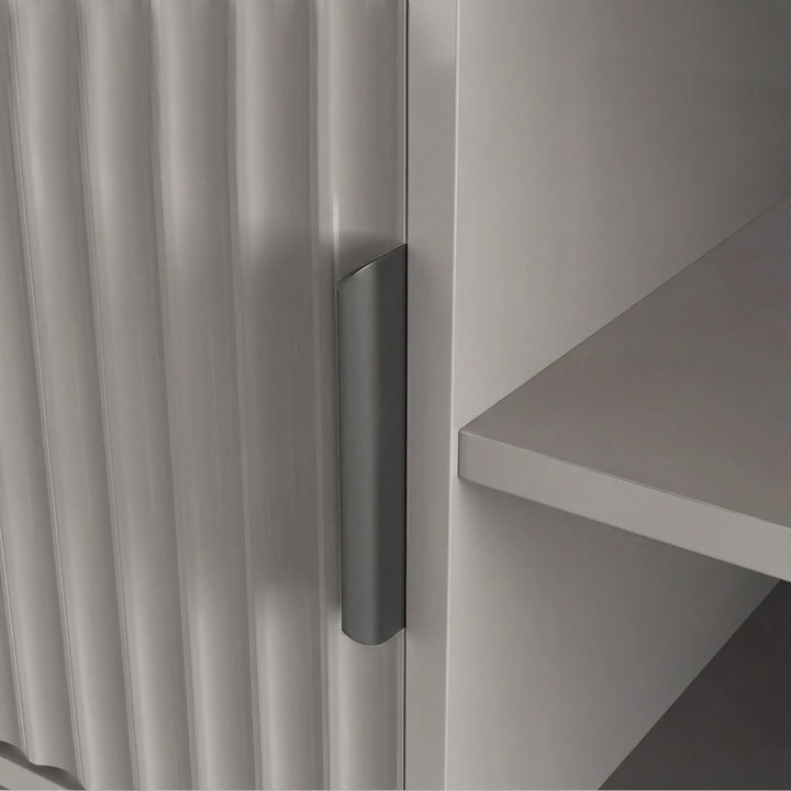 [Grey] Macro view of grey Flutrina TV cabinet door edge, ribbed panel and silver handle next to interior shelf