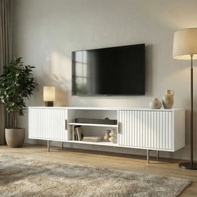 White TV entertainment unit featuring vertical fluted doors and silver legs for a bright, modern living room style.