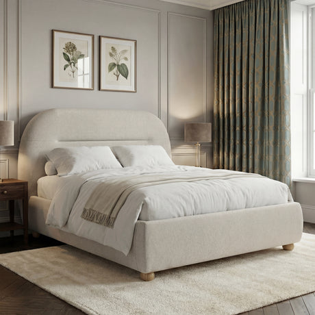 Side view of beige upholstered double bed frame with curved edges and a soft headboard