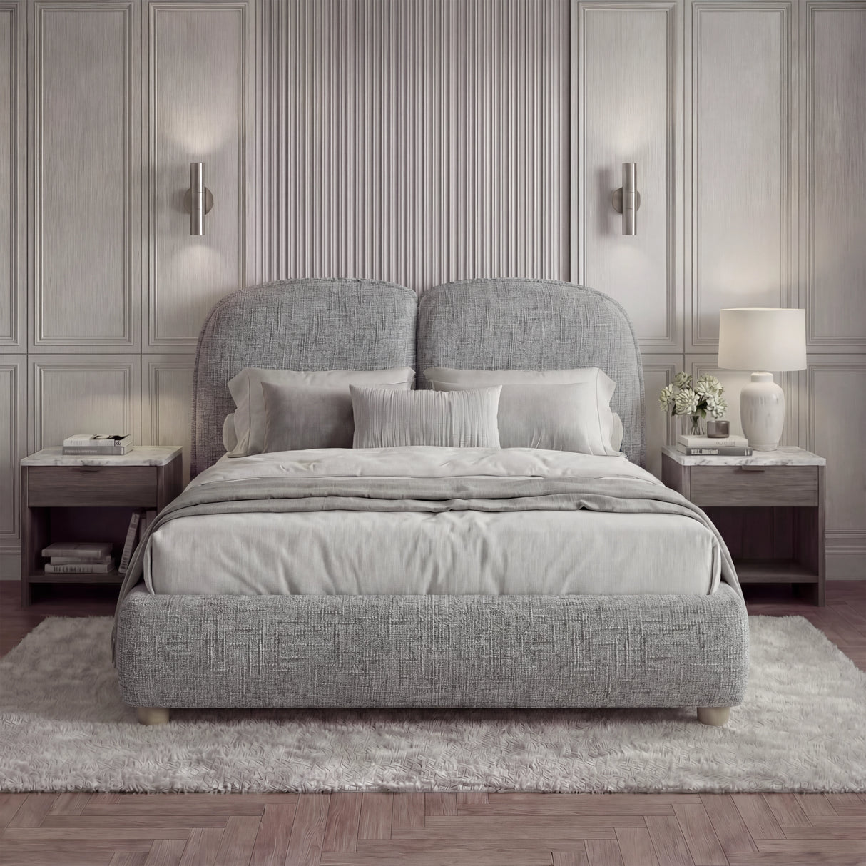 Upholstered grey double bed frame with a soft padded headboard and wooden legs in a natural light bedroom setting