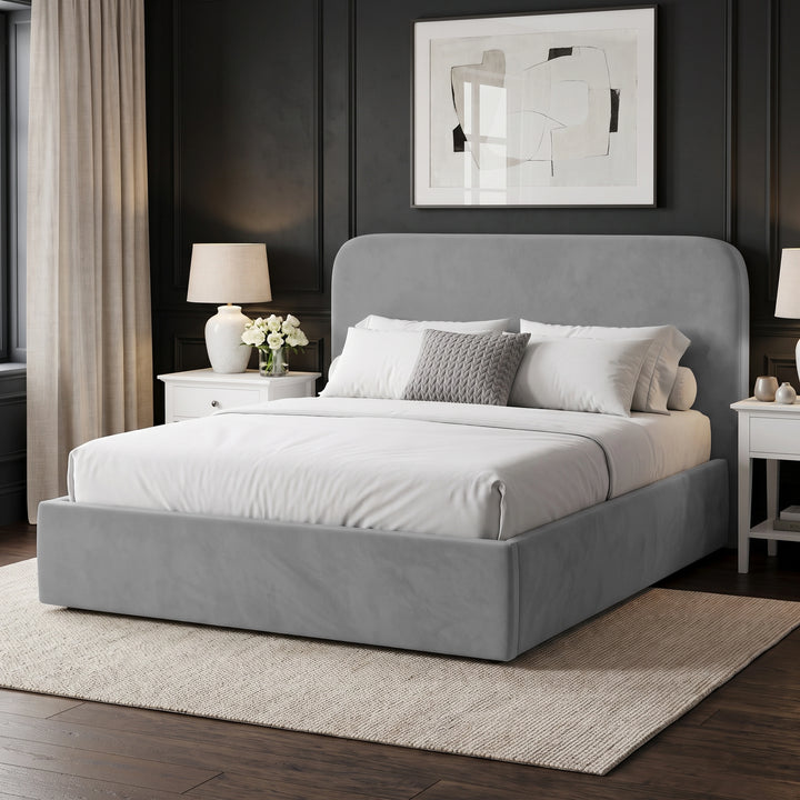 [Light Grey | King] upholstered bed frame with a matching headboard, dressed in white bedding and pillows, set in a modern bedroom with dark paneled walls, white nightstands, lamps, and a beige rug.