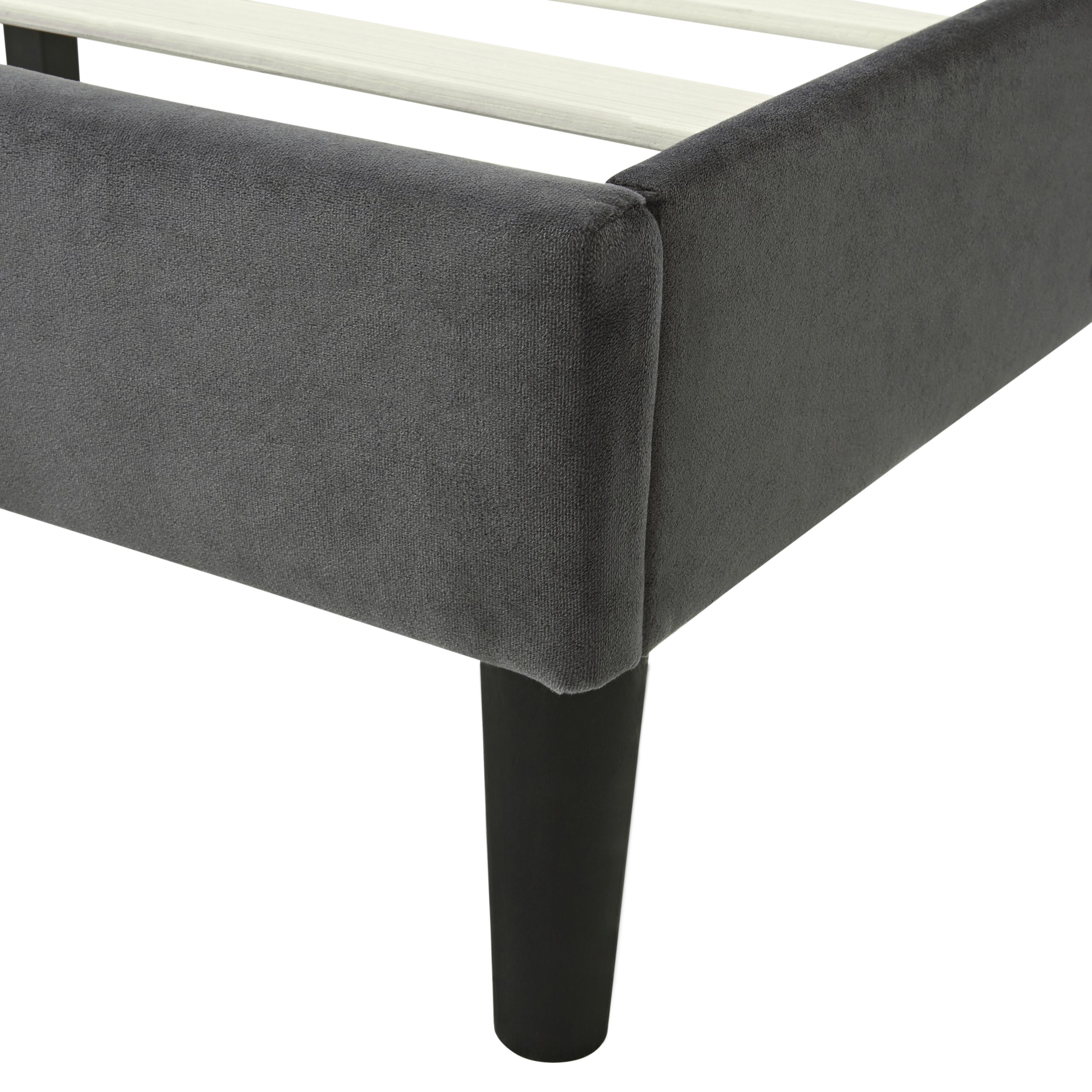 Close-up of grey velvet ottoman bed frame with sturdy black legs and wooden slats.