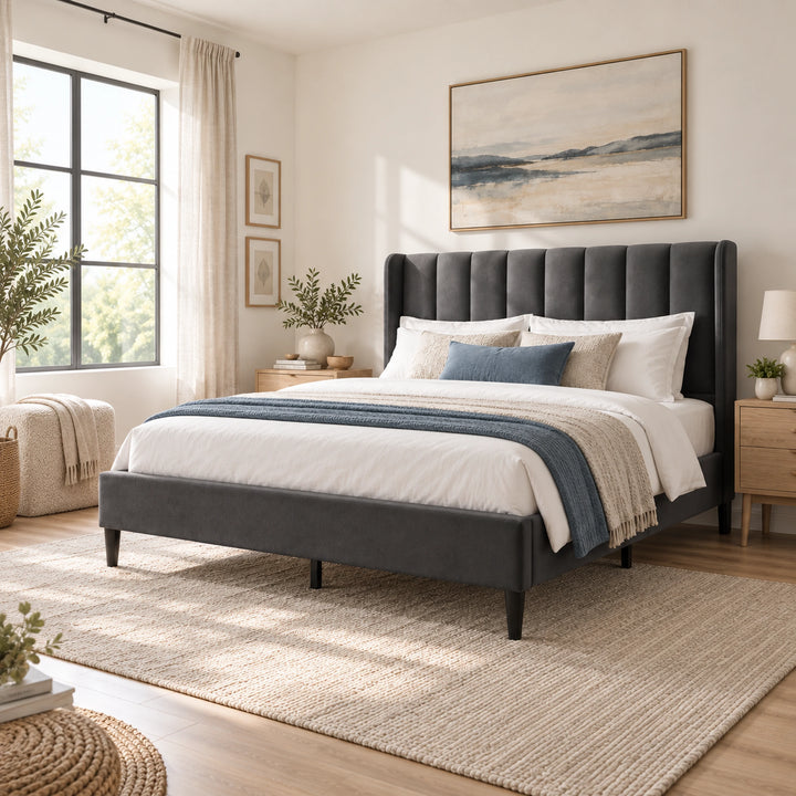 [Double | Grey] upholstered bed with a tall tufted headboard, dressed in white bedding with blue accents, set in a bright, neutral-toned bedroom with a large woven rug and natural light from a window.