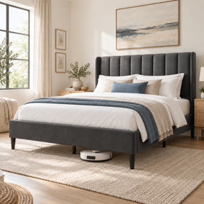 [Double | Grey] upholstered bed frame with a tall channel-tufted headboard, styled in a bright, modern bedroom with white bedding, a blue throw blanket, and a robotic vacuum underneath.