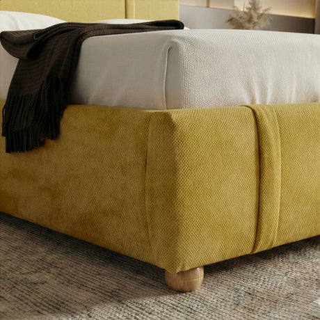 [Double | Yellow] Close-up of footboard corner showing rounded padded edge with wooden ball foot on grey rug
