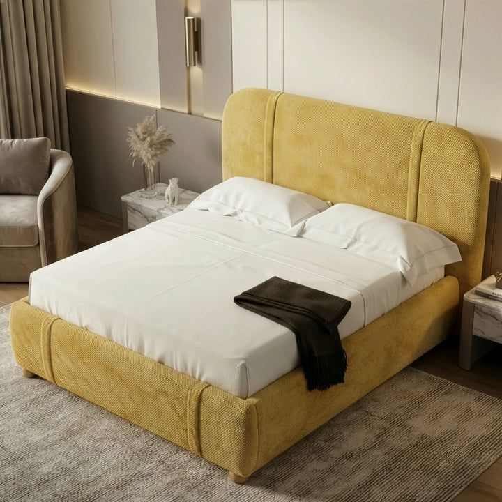 [Double | Yellow] Top-down angle of yellow upholstered bed showing curved headboard, white bedding and pampas at left