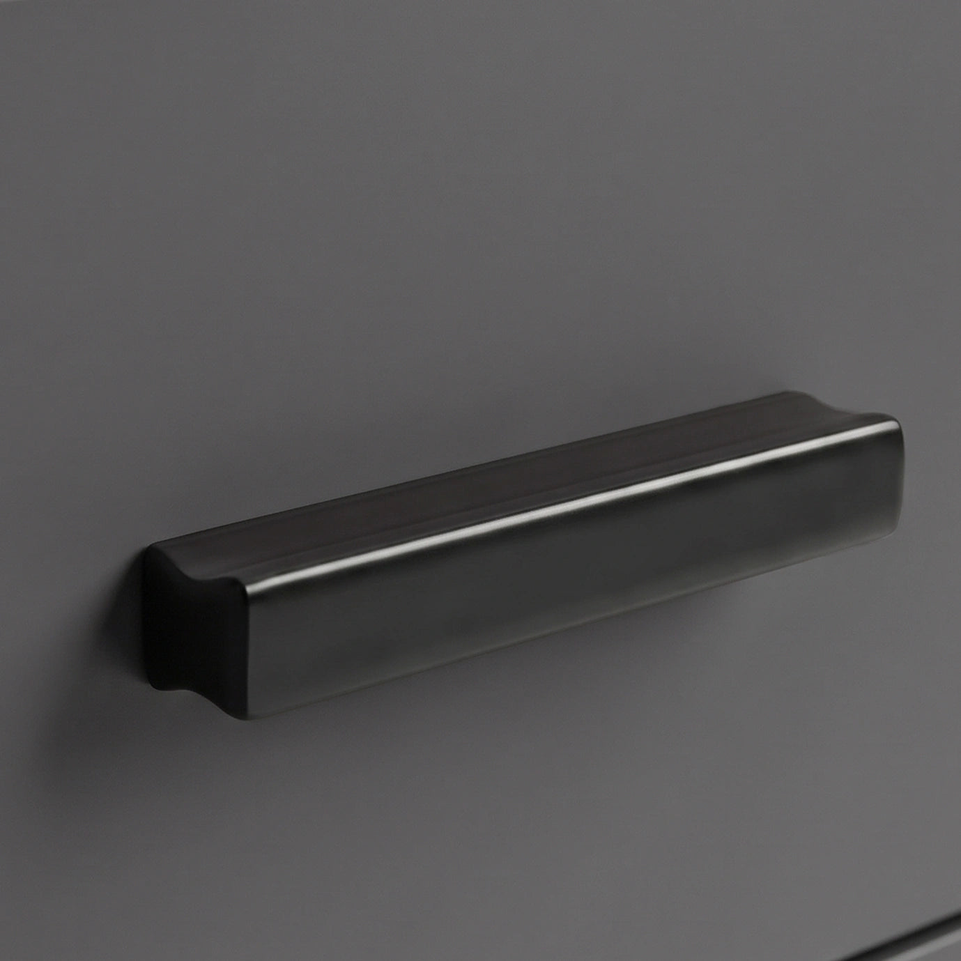 [Walnut] Close up of walnut grey drawer front with matte black wooden handle and smooth painted surface