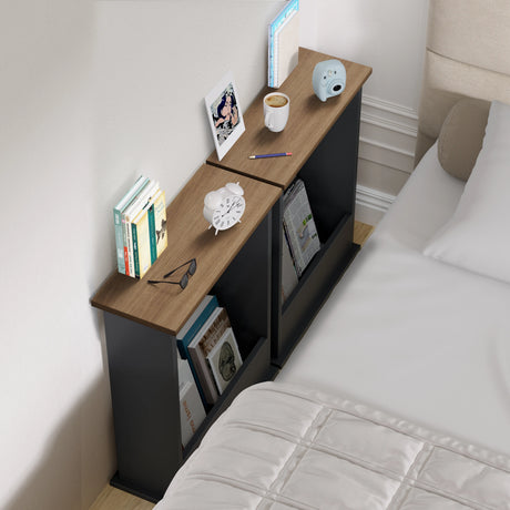 Corner nightstand with books, a cup, and other items next to a bed.