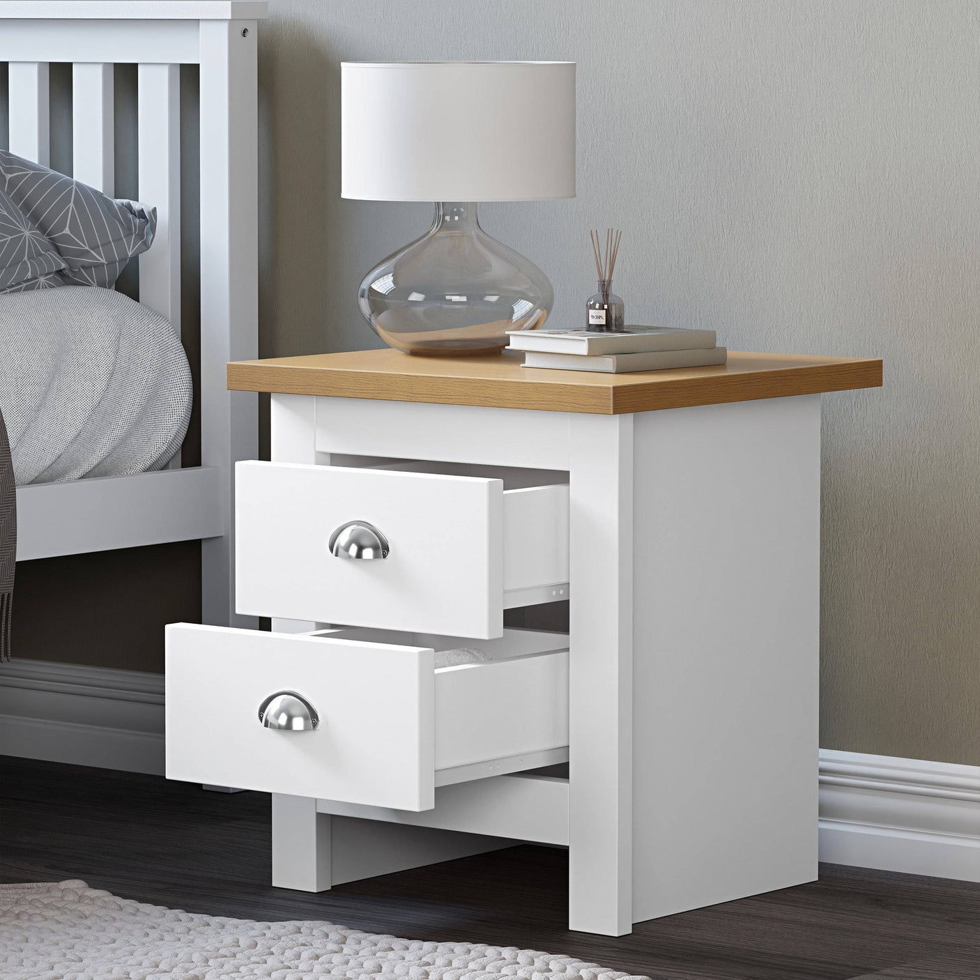 White 2 drawer bedside table with top surface for books and lamp, offering stylish storage.
