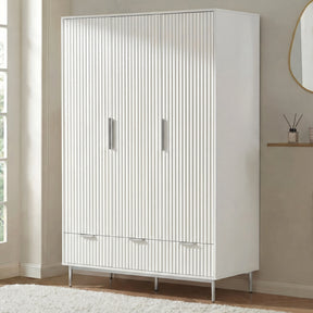 White three door wardrobe with lower drawers placed in room setting with soft neutral decor