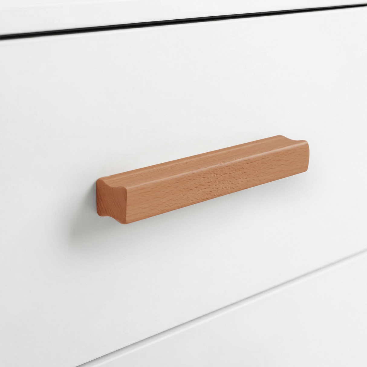 [White] Close up of white drawer front with solid wooden handle and clean painted surface detail
