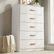 [White] five drawer chest styled in neutral interior with floor vase, wall art and wooden handles