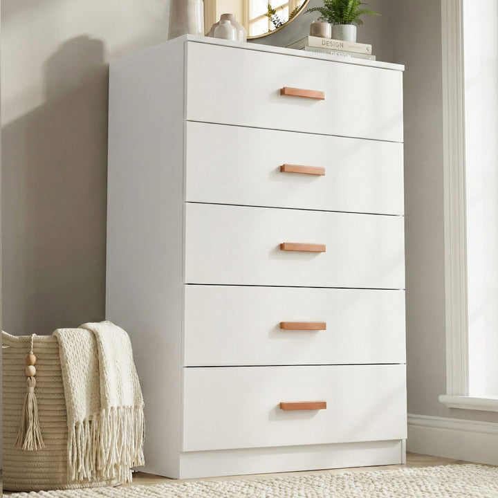 [White] five drawer chest styled in neutral interior with floor vase, wall art and wooden handles