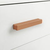 [White] Close up of white five drawer front with horizontal wooden handle and clean painted surface detail
