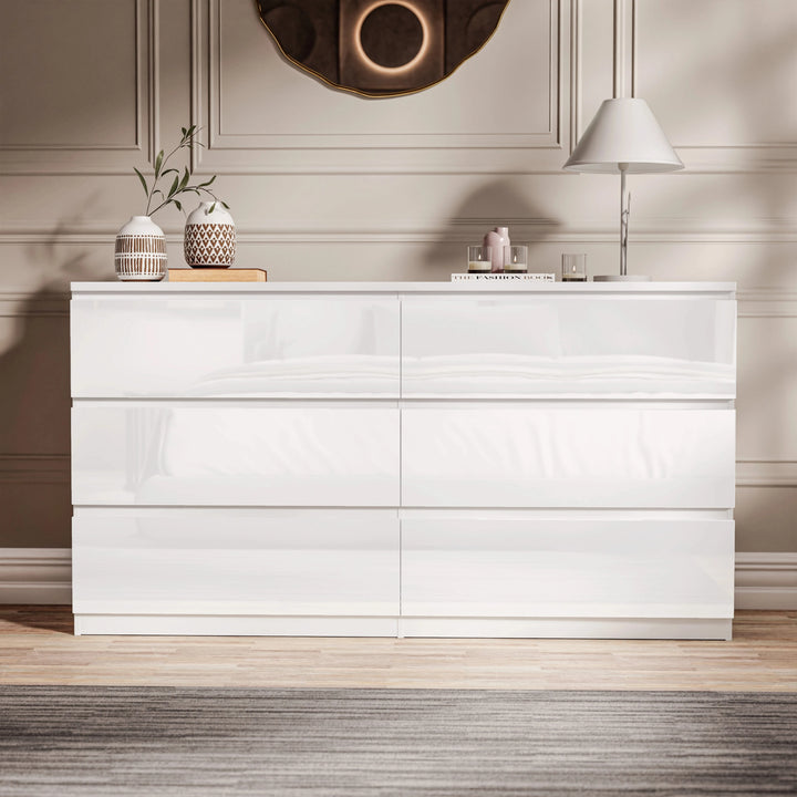 [White] Straight-on view of white 6 drawer chest with round wall mirror and tall lamp.