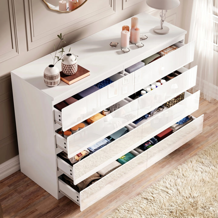 [White] high gloss wide chest of drawers fully open displaying folded textiles in every drawer