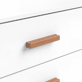 [White] Close view of a wooden horizontal handle fixed to a white drawer front with visible grain and smooth finish