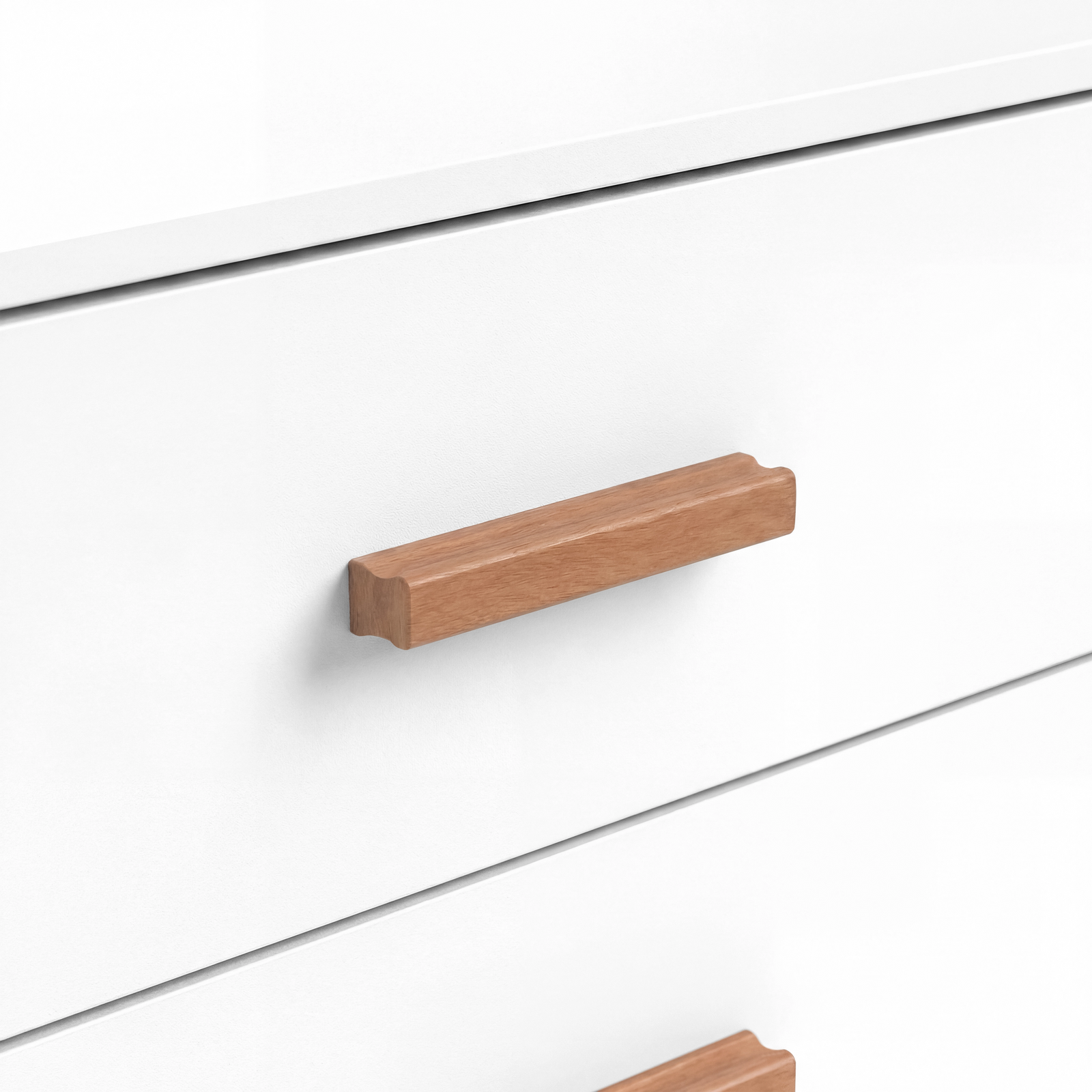 [White] Close view of a wooden horizontal handle fixed to a white drawer front with visible grain and smooth finish