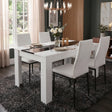 [4 Seater | White] White & Black Gloss 4-6 Seater Dining Table with four white faux-leather chairs and a rose centrepiece on a dark shag rug beneath 