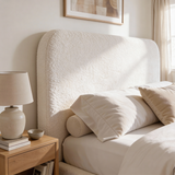 Close view of white boucle double bed headboard with soft textured upholstery and gently curved padded design