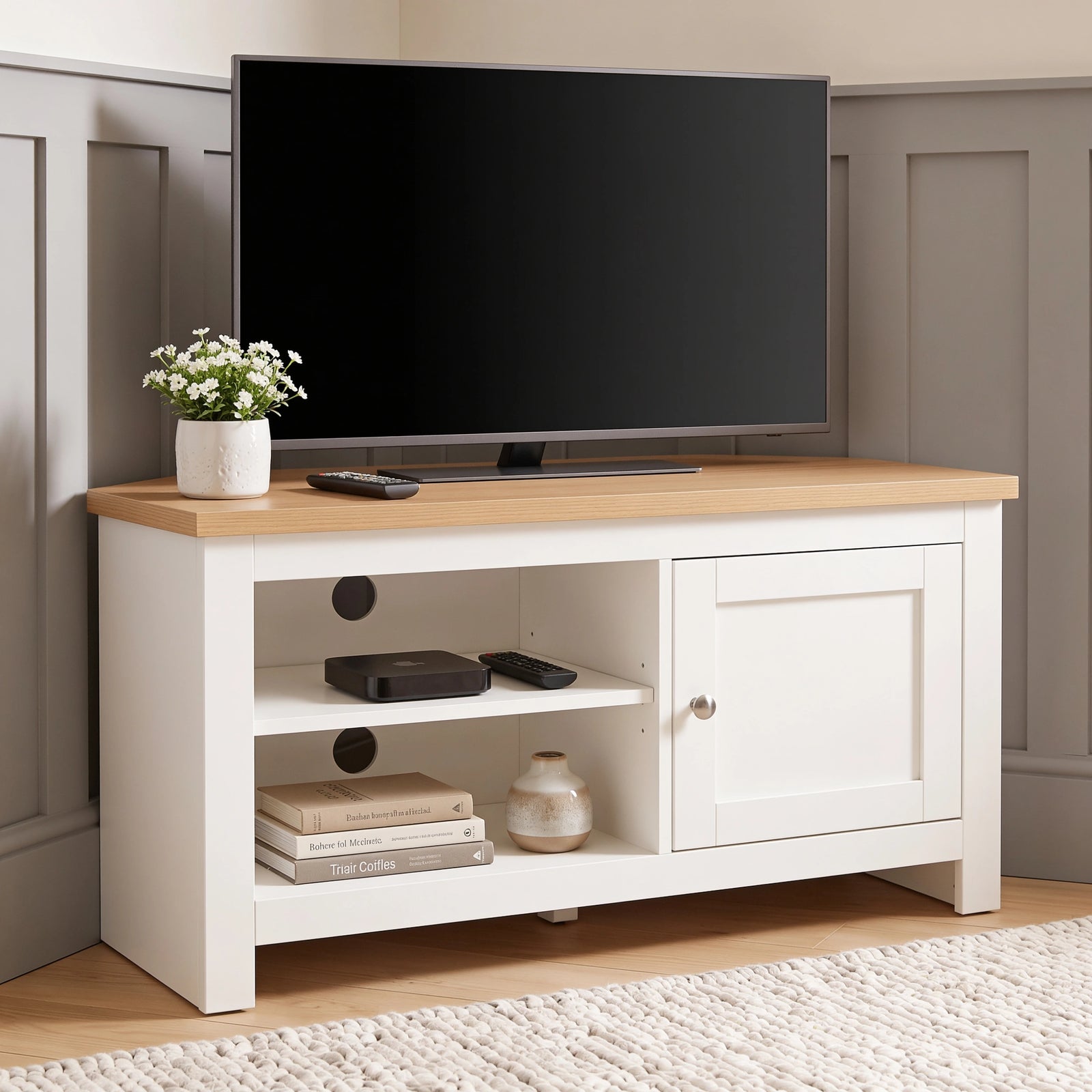 [White] TV stand with a light wood top, shown in a styled room setting with a flat-screen TV, a small potted plant, and decorative items on and inside the shelves