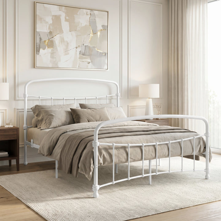 [White | King] White metal bed frame with taupe bedding, shown at a 3/4 Angle in a bright bedroom with a rug.