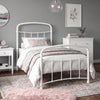 [White | Single] White metal bed frame with white bedding, shown at a 3/4 Angle in a bright bedroom with a rug.