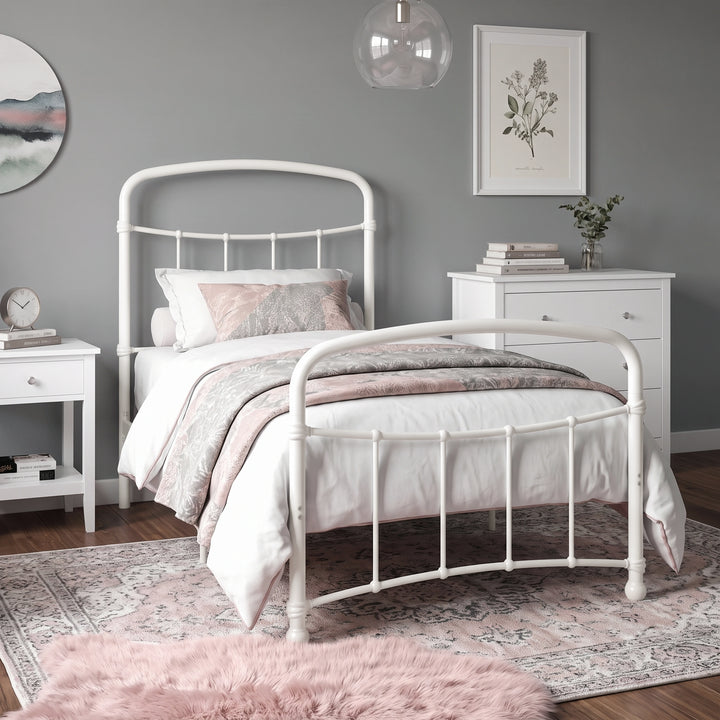 [White | Single] White metal bed frame with white bedding, shown at a 3/4 Angle in a bright bedroom with a rug.
