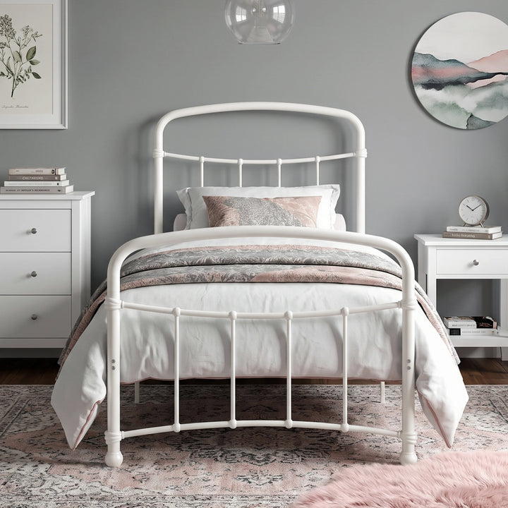 [White | Single] Front view of a white metal bed frame with curved rails and white bedding in a bright bedroom.
