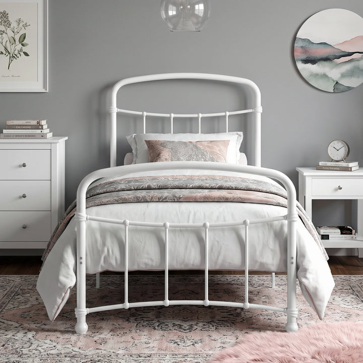 [White | Single] Front view of a white metal bed frame with curved rails and white bedding in a bright bedroom.