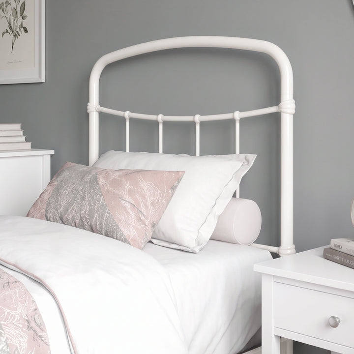 [White | Single] Close-up of the white curved headboard with vertical bars, white pillows and light bedding.