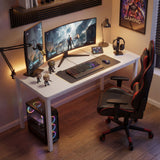 [100 x 50 cm] Home Office Desk 100cm angled gaming room setup with dual curved monitors, microphone arm, RGB keyboard, collectible figures, and red gaming chair in warm amber lighting