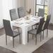 Modern white dining table paired with six grey chairs, creating a stylish and functional space for family dining."