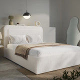 Modern bedroom with a white upholstered bed and decorative pillows.