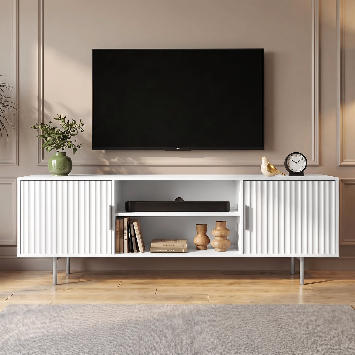 [White] Flutrina TV unit front view with fluted doors, open shelves, wall TV, plant, clock, bird ornament, books, and vases.