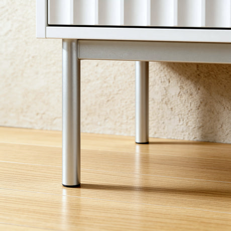 [White] Flutrina wardrobe silver cylindrical metal legs resting on wooden floor with fluted drawer front above