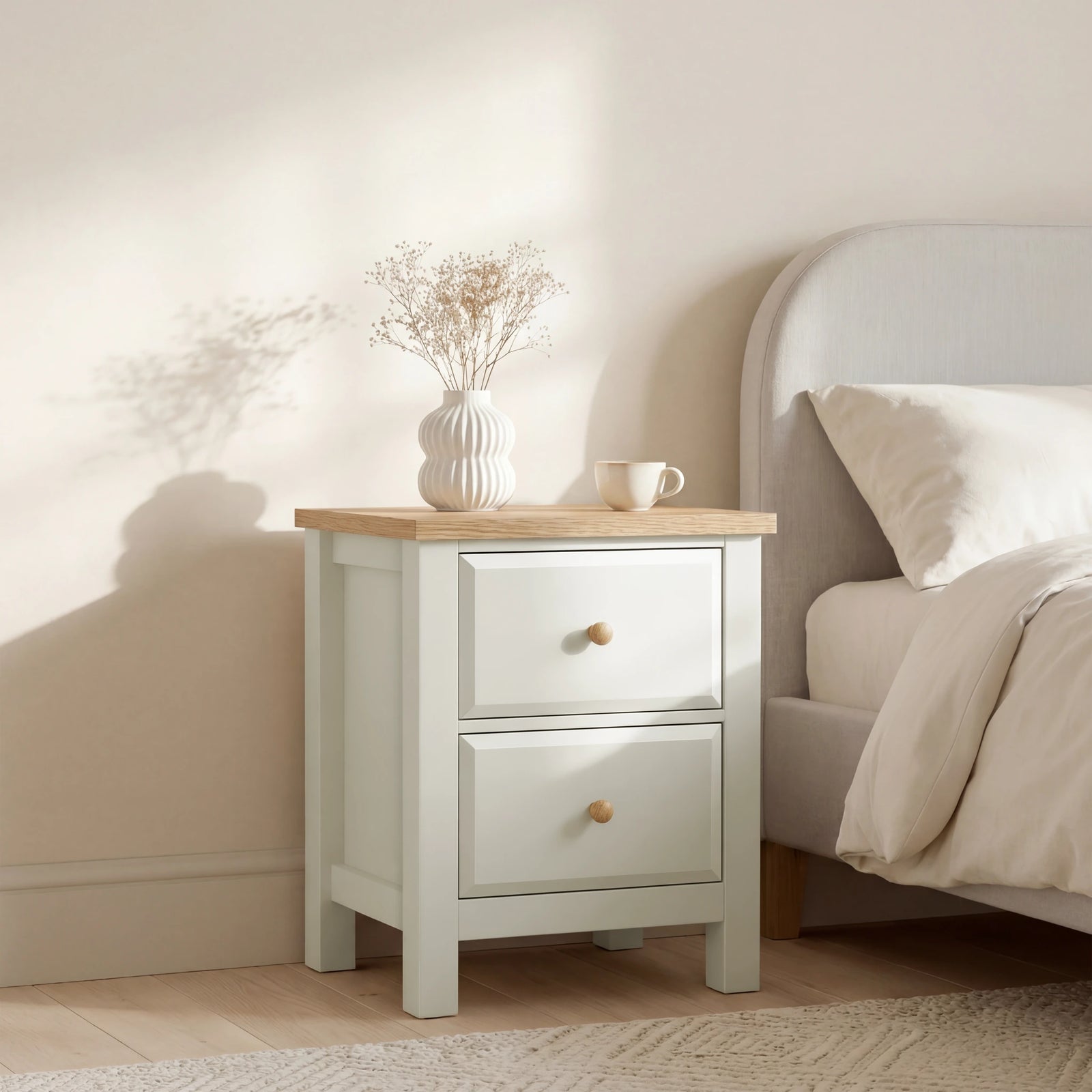 [White] nightstand with wooden top next to a bed in a bedroom setting