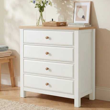 [White] Haven 4 drawer chest with oak top and round oak knobs shown at a three-quarter angle in a warm neutral bedroom