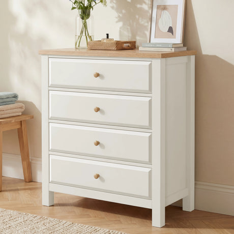 [White] Haven 4 drawer chest with oak top and round oak knobs shown at a three-quarter angle in a warm neutral bedroom
