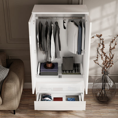 Interior of white high gloss wardrobe showing hanging rail and two drawers. Organized storage for clothes and accessories in small bedrooms.
