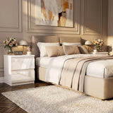 [White]  Neatly made bed in a bedroom with decorative elements.
