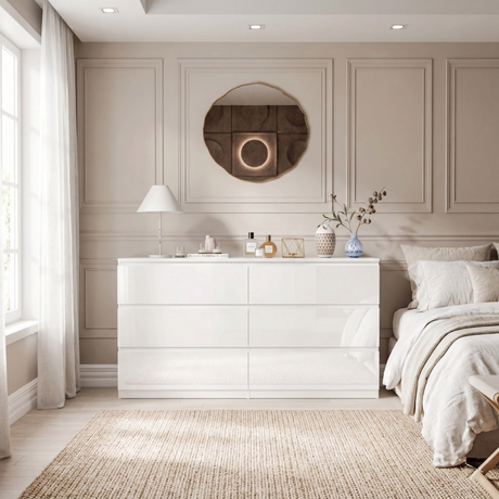 A white high gloss dresser placed against a wall with a bed, and decorative elements in a modern bedroom