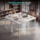 [120 x 50 cm] Home Office Desk arranged in an artist studio with sketches, paint jars, brushes, and laptop, set against exposed brick walls and large industrial windows