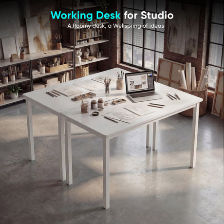 [120 x 50 cm] Home Office Desk arranged in an artist studio with sketches, paint jars, brushes, and laptop, set against exposed brick walls and large industrial windows
