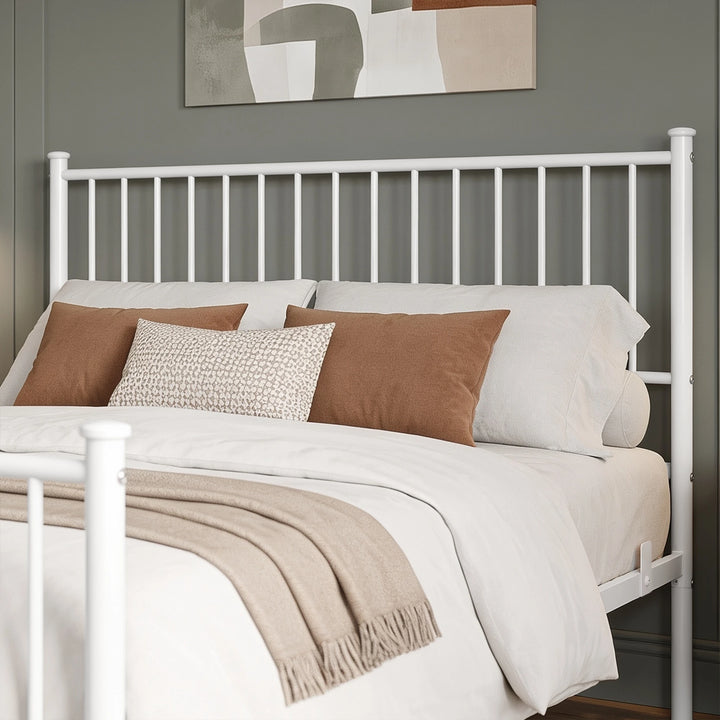 [White | King] Headboard close-up showing vertical bars, capped posts, rust cushions, textured pillow, and fringed throw.