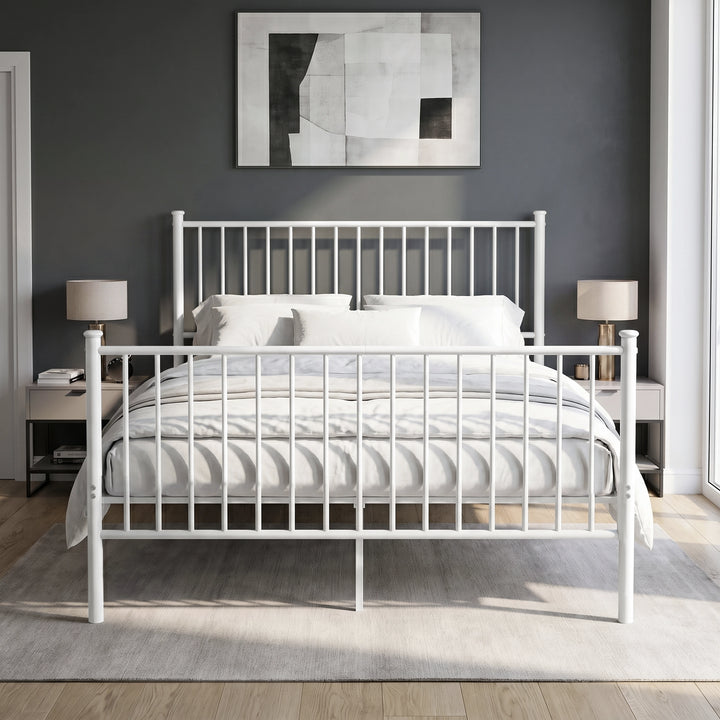 [White | King] Front view of metal bed with white-grey bedding, bar ends, centre leg, two bedside lamps and abstract wall art
