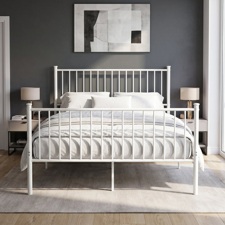 [White | King] Front view of metal bed with white-grey bedding, bar ends, centre leg, two bedside lamps and abstract wall art