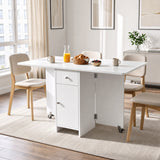 [White] Kitchen drop leaf table fully open and locked via caster supports styled with four chairs, orange juice and mugs.