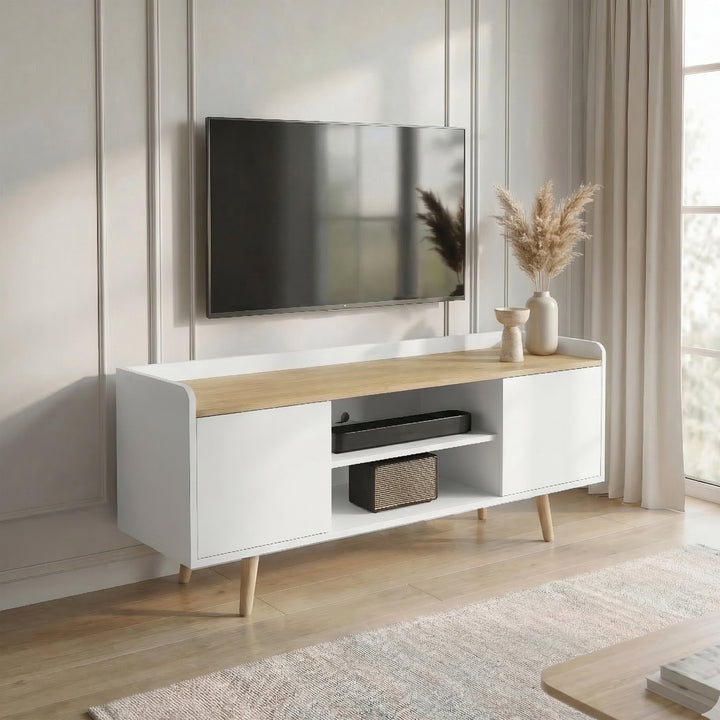 [White | 112 cm] Larvik styled at an angle in a sunlit panelled room with wall-mounted TV, pampas grass, soundbar, and woven speaker