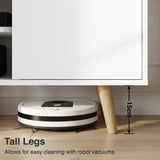 [White | 112 cm] Larvik close-up of 15cm tapered oak legs with robot vacuum passing underneath on wooden floor in grey-toned room